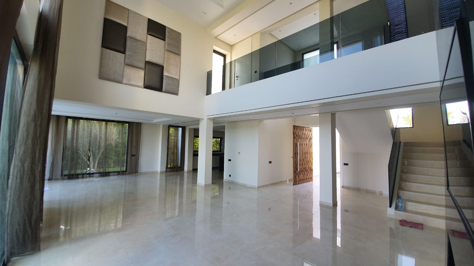 Grand espace intérieur en double hauteur avec escalier et garde-corps vitrés